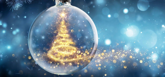 Ein Weihnachtsbaum aus gelben Lichtern ist in eine Weihnachtsbaumkugel aus Glas eingeschlossen.