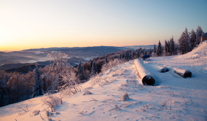 Weiße Nahrungsergänzungsmitteltabletten liegen auf einem blauen Hintergrund verteilt und formen Schneeflockenmuster.